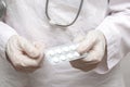 Doctor woman in a medical coat and gloves holds pills in her hands. Pills in the hands of a doctor close-up Royalty Free Stock Photo