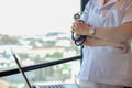 Doctor woman in medical office feeling refreshed in the morning, smiling face receiving golden light. Female doctor uniform with.