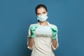 Doctor woman or medical specialist wearing professional medical uniform and protective mask holding protective medical mask on