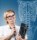 Doctor woman pointing on drawing human skeleton. Royalty Free Stock Photo