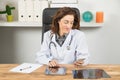 Doctor woman reading mobile phone in office Royalty Free Stock Photo