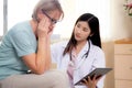 Doctor woman and senior patient explaining and looking on tablet computer for diagnostics and examining disease. Royalty Free Stock Photo