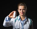 Doctor woman showing medicine bottle on black background Royalty Free Stock Photo