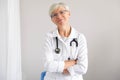 Doctor woman smiles and folds arms on chest. Portrait medical