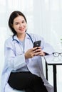 Doctor woman smiling using working with smart mobile phone Royalty Free Stock Photo