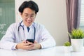 Doctor woman smiling using working with smart mobile phone Royalty Free Stock Photo