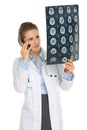 Doctor woman speaking phone and looking on MRI Royalty Free Stock Photo