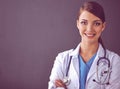 Doctor woman with stethoscope standing near grey wall