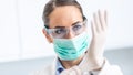 Doctor woman surgeon specialist in sterile clothing putting on surgical gloves Royalty Free Stock Photo