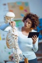 Doctor woman teaching anatomy using human skeleton model Royalty Free Stock Photo