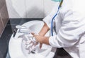 Doctor woman wear hygiene mask and stethoscope washing and cleaning hands rubbing with soap Royalty Free Stock Photo