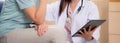 Doctor woman and senior patient explaining and looking on tablet computer for diagnostics and examining disease. Royalty Free Stock Photo