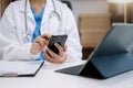 Doctor work on digital smartphonr and tablet healthcare doctor technology tablet using computer in a modern office in the morning Royalty Free Stock Photo