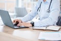 Doctor at work. An unrecognizable doctor using a laptop in an office at a hospital.