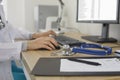 Doctor working at computer and typing electronic medical record sitting near stethoscope. Royalty Free Stock Photo