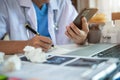 Doctor working on laptop computer and tablet and medical stethoscope on clipboard on desk, electronics medical record system EMRs