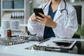 Doctor working on laptop computer and tablet and medical stethoscope on clipboard on desk, electronics medical record system EMRs Royalty Free Stock Photo