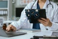 Doctor working on laptop computer and tablet and medical stethoscope on clipboard on desk, electronics medical record system EMRs Royalty Free Stock Photo