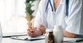 Doctor working on laptop computer and tablet and medical stethoscope on clipboard on desk, electronics medical record system EMRs