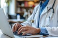 Doctor working with laptop computer and writing on paperwork. Hospital background Royalty Free Stock Photo