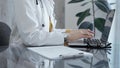 Doctor working on laptop with stethoscope on the glass desk. Medicine and Health care