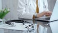 Doctor working on laptop with stethoscope on the glass desk. Medicine and Health care Royalty Free Stock Photo