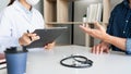 Doctor working with patient taking notes with clipboard and discussing something in his medical office, health care and people Royalty Free Stock Photo