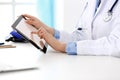 Doctor working table. Woman physician using tablet computer while sitting in hospital office close-up. Healthcare Royalty Free Stock Photo