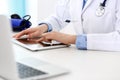 Doctor working table. Woman physician using tablet computer while sitting in hospital office close-up. Healthcare Royalty Free Stock Photo