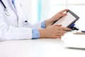 Doctor working table. Woman physician using tablet computer while sitting in hospital office close-up. Healthcare Royalty Free Stock Photo