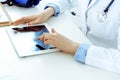 Doctor working table. Woman physician using tablet computer while sitting in hospital office close-up. Healthcare Royalty Free Stock Photo