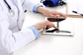 Doctor working table. Woman physician using tablet computer while sitting in hospital office close-up. Healthcare Royalty Free Stock Photo