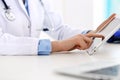 Doctor working table. Woman physician using tablet computer while sitting in hospital office close-up. Healthcare Royalty Free Stock Photo