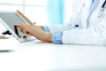 Doctor working table. Woman physician using tablet computer while sitting in hospital office close-up. Healthcare Royalty Free Stock Photo