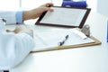 Doctor working table. Woman physician using tablet computer while sitting in hospital office close-up. Healthcare Royalty Free Stock Photo