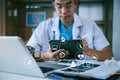 Doctor working on tablet and laptop computer and medical stethoscope on clipboard on desk, electronics medical record system EMRs Royalty Free Stock Photo