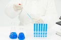 Doctor working on test tubes filled with blue liquid on the table in a medical laboratory Royalty Free Stock Photo