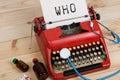 doctor workplace with blue stethoscope, pills, red typewriter with text WHO World Health Organization