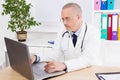 Doctor works at the computer in his office in clinic