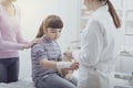 Doctor wrapping a girl`s injured wrist with a bandage Royalty Free Stock Photo