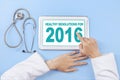 Doctor writes healthy resolution for 2016 on tablet Royalty Free Stock Photo