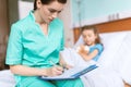 Doctor writing in clipboard diagnosis of sick little girl