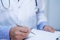 Doctor writing down the diagnosis on clipboard while Asian senior or elderly old lady woman lying on bed in nursing hospital Royalty Free Stock Photo