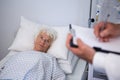 Doctor writing medical details of a senior patient