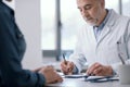 Doctor writing a medical prescription for his patient Royalty Free Stock Photo