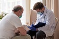 Doctor writing medical prescription to elderly man