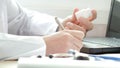 Doctor writing a prescription at desk i