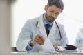 Doctor writing prescription at desk in hospital Royalty Free Stock Photo