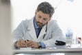 Doctor writing prescription at desk in hospital Royalty Free Stock Photo