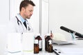 Doctor writing prescription at desk in medical office with drugs Royalty Free Stock Photo